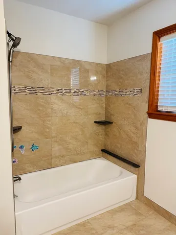 a bathroom with a bathtub and shower
