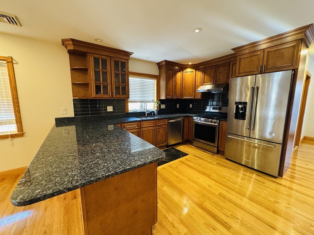 162 Palmer Street Quincy, MA 02169 - Photo 4 of 21 a kitchen with stainless steel appliances granite countertop a sink refrigerator and microwave