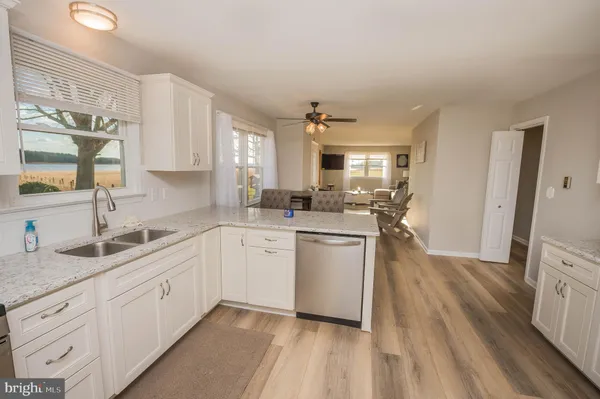 a kitchen with sink a refrigerator and white cabinets