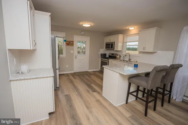 a kitchen with a table chairs refrigerator and cabinets