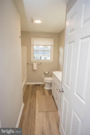 a bathroom with a sink a toilet and a window