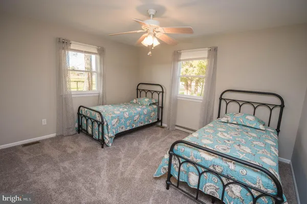 a bedroom with a bed window and a chandelier