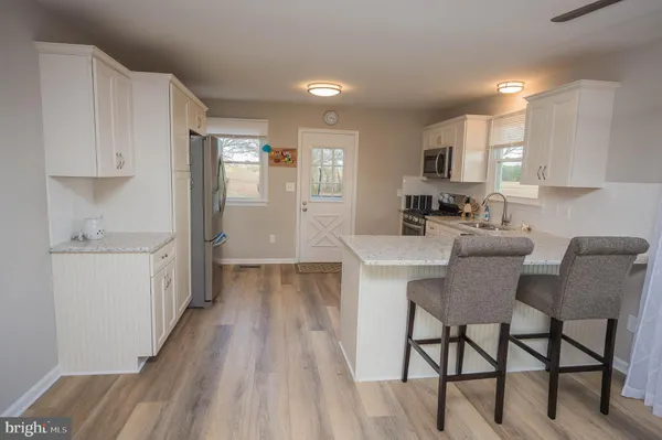 a kitchen with a dining table chairs and white cabinets