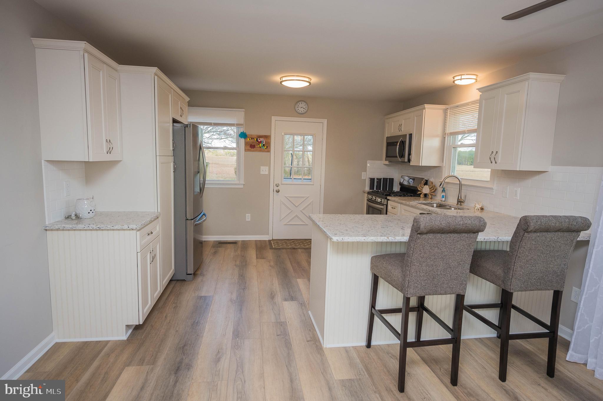 3555 Green Hill Church Road Quantico, MD 21856 - Photo 10 of 51 a kitchen with a dining table chairs and white cabinets