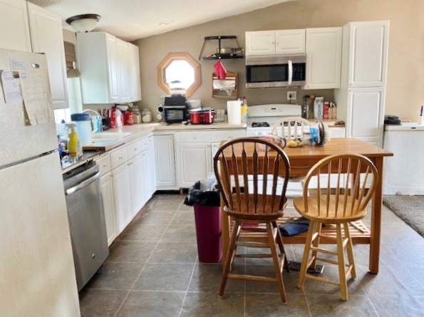 21374 Coleta Road Sterling, IL 61081 - Photo 8 of 19 a kitchen with stainless steel appliances a table chairs and a refrigerator