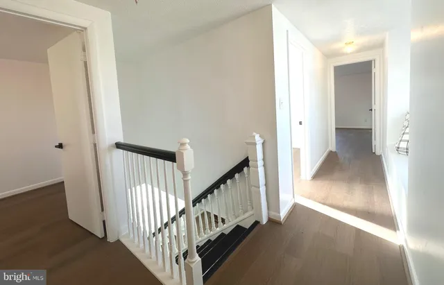 a view of a hallway with wooden floor and entryway