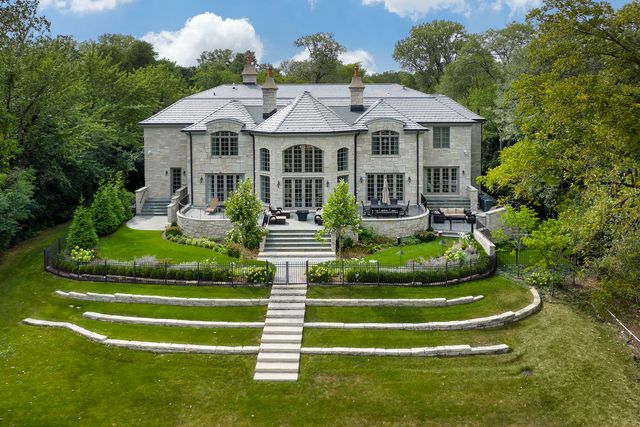 a front view of a house with a garden and plants