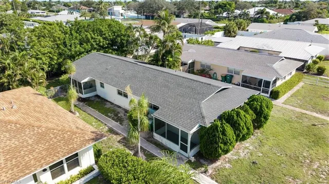 an aerial view of a house with a yard garage and lake view