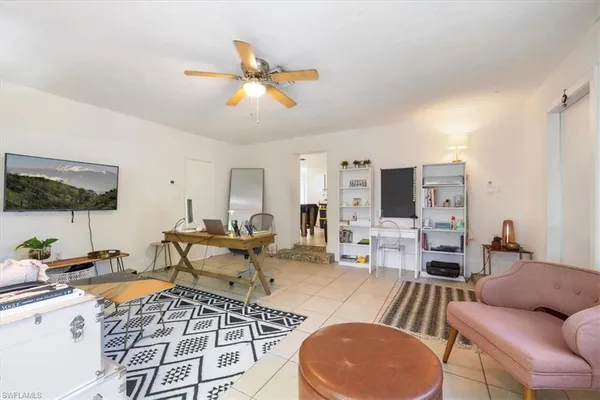 a living room with furniture a flat screen tv and kitchen view