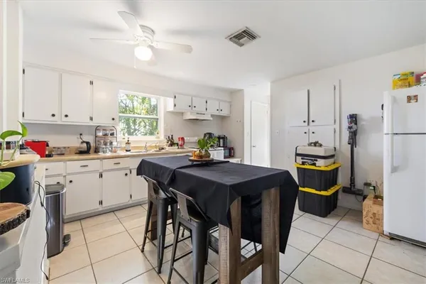 a kitchen with a table chairs and refrigerator