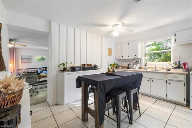 a kitchen with a table chairs sink and cabinets