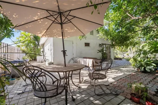 a view of a patio with table and chairs under an umbrella