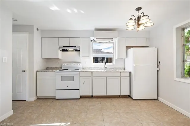 a kitchen with white cabinets and white appliances