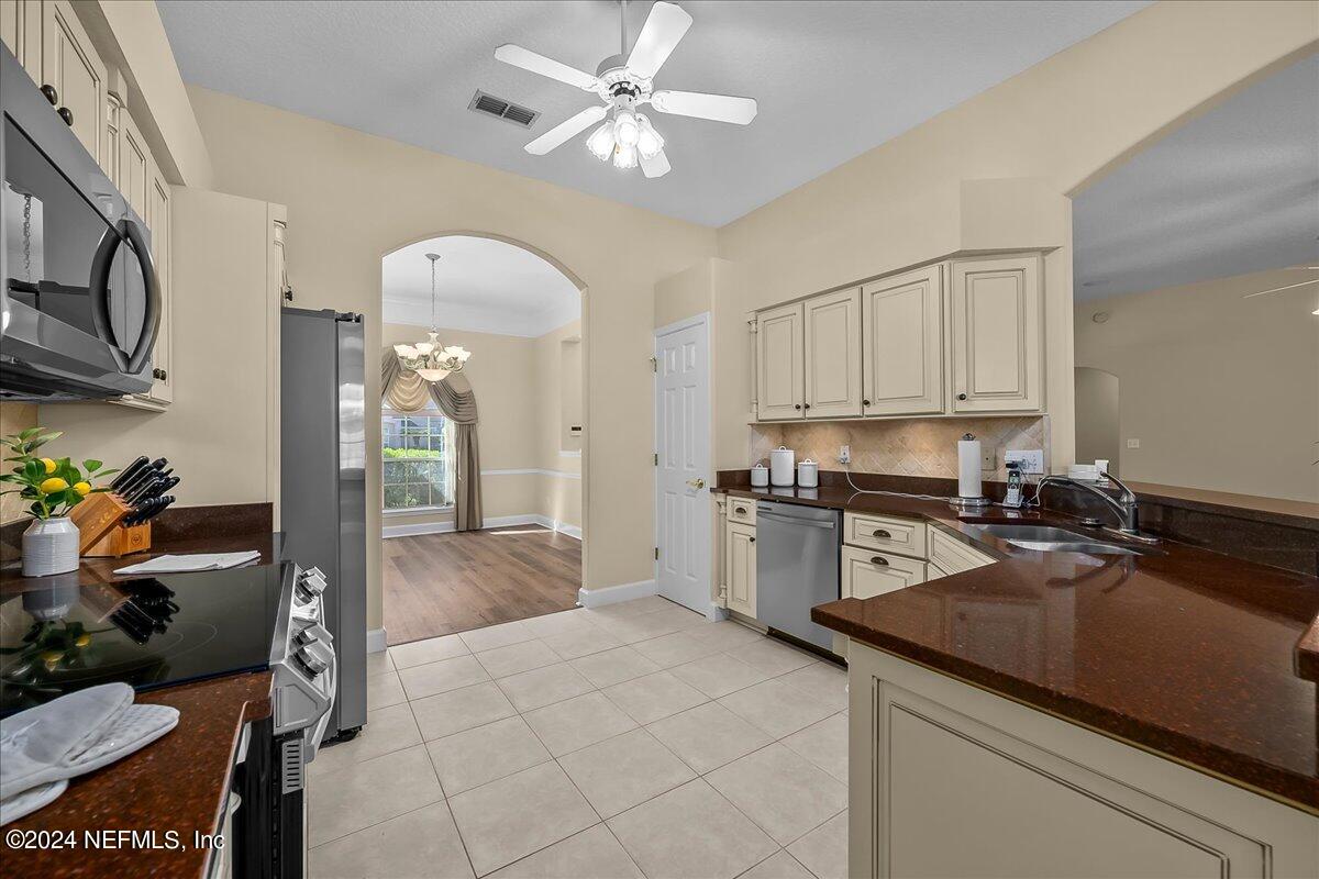 10285 Hamlet Glen Drive Jacksonville, FL 32221 - Photo 11 of 26 a kitchen with a stove a refrigerator and a sink