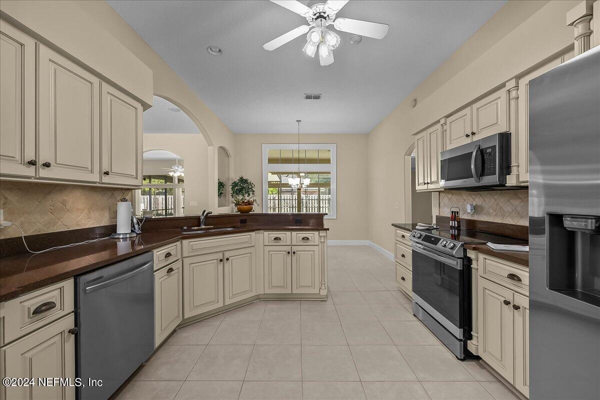 10285 Hamlet Glen Drive Jacksonville, FL 32221 - Photo 12 of 26 a kitchen with stainless steel appliances granite countertop a stove top oven a sink dishwasher and a microwave oven on the blue kitchen countertops