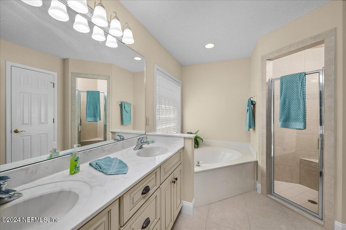 10285 Hamlet Glen Drive Jacksonville, FL 32221 - Photo 19 of 26 a bathroom with a granite countertop sink and a bathtub