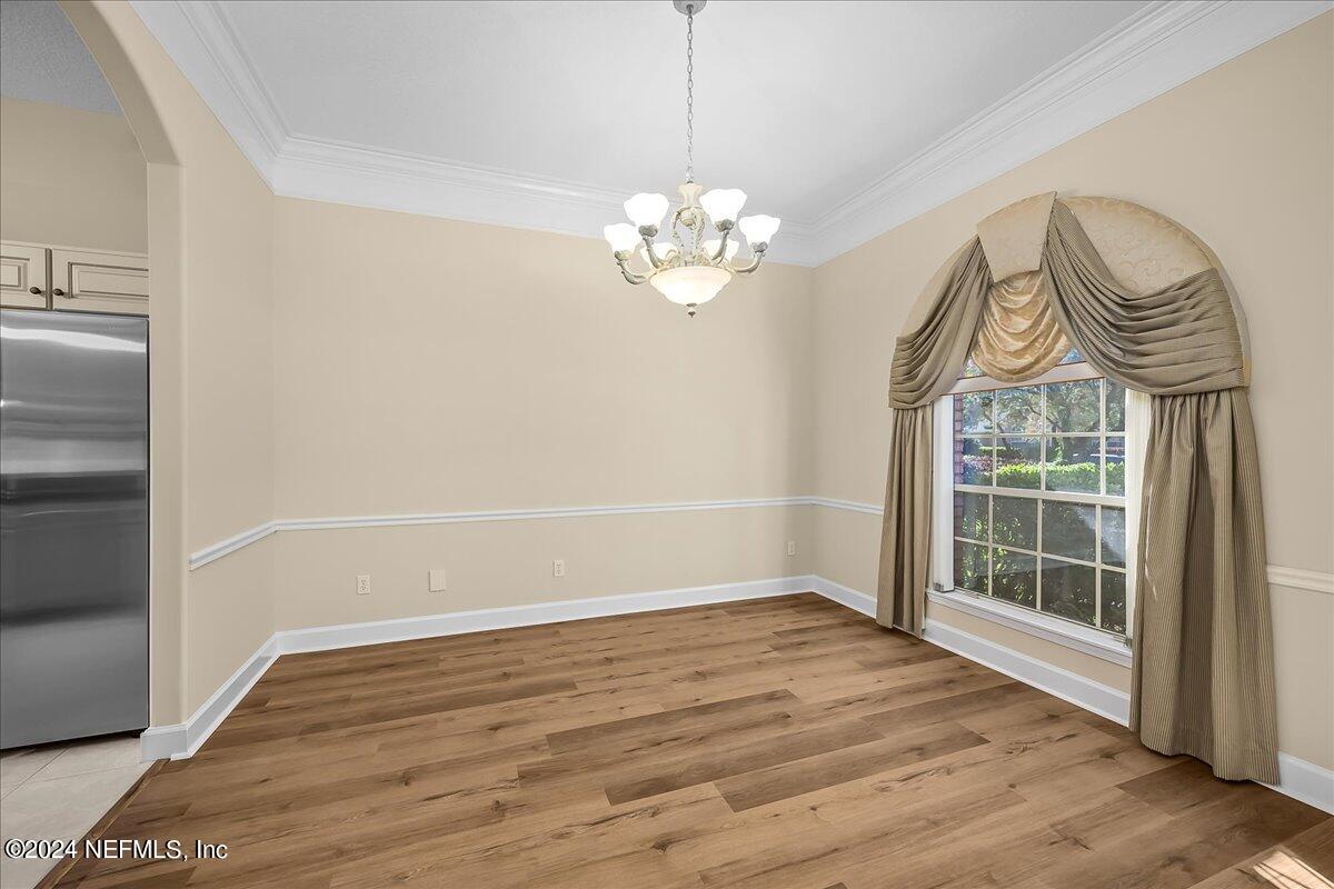 10285 Hamlet Glen Drive Jacksonville, FL 32221 - Photo 7 of 26 a view of an empty room with wooden floor and a window