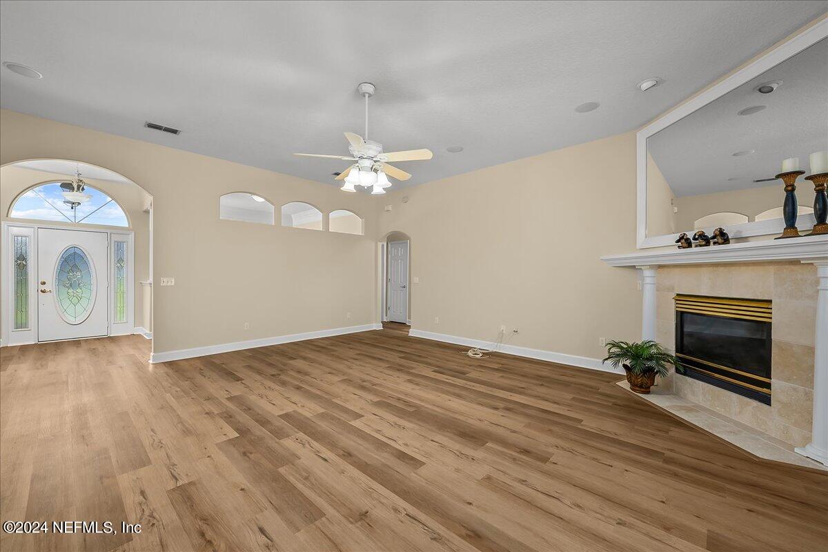10285 Hamlet Glen Drive Jacksonville, FL 32221 - Photo 9 of 26 a view of an empty room with wooden floor and fireplace