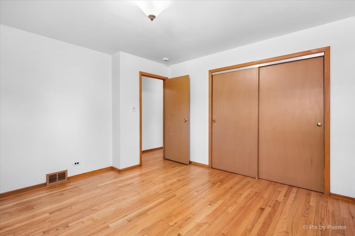 970 Fischer Drive Addison, IL 60101 - Photo 11 of 32 an empty room with wooden floor and closet area