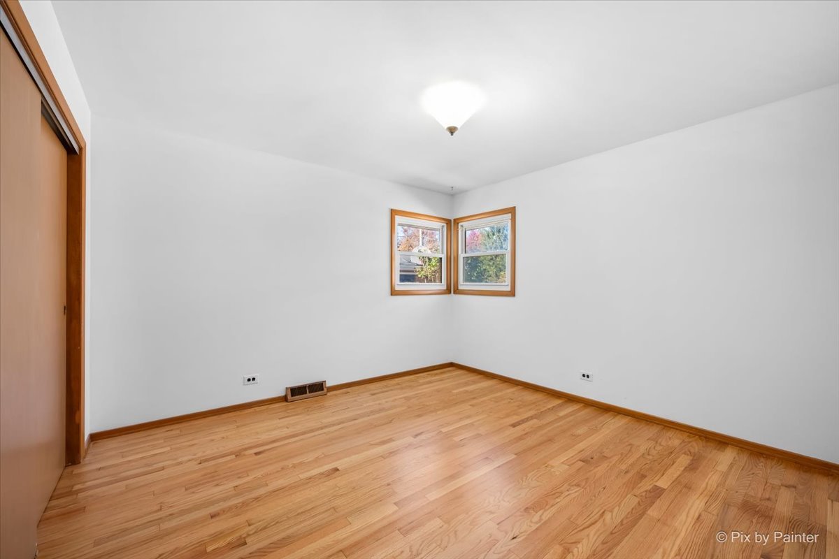970 Fischer Drive Addison, IL 60101 - Photo 13 of 32 an empty room with wooden floor and windows
