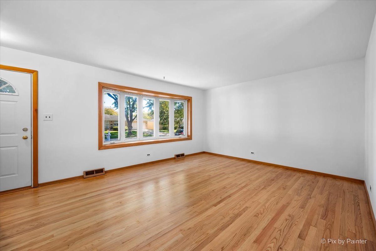 970 Fischer Drive Addison, IL 60101 - Photo 6 of 32 a view of an empty room with wooden floor and a window