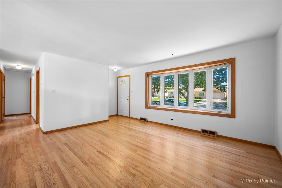 970 Fischer Drive Addison, IL 60101 - Photo 7 of 32 a view of an empty room with wooden floor and a window