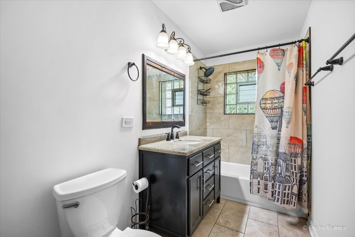 970 Fischer Drive Addison, IL 60101 - Photo 9 of 32 a bathroom with a sink a toilet and shower curtain