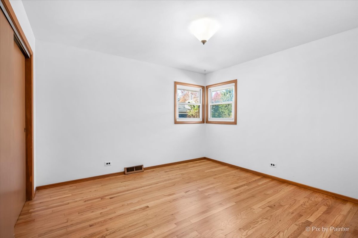 970 Fischer Drive Addison, IL 60101 - Photo 10 of 32 an empty room with wooden floor and windows