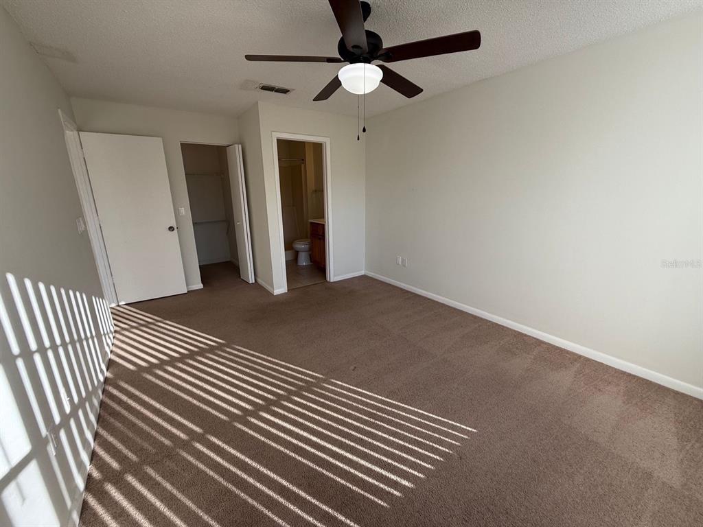 6334 Spring Flower Drive, Unit 14 New Port Richey, FL 34653 - Photo 7 of 25 en empty room with wooden floor and ceiling fan
