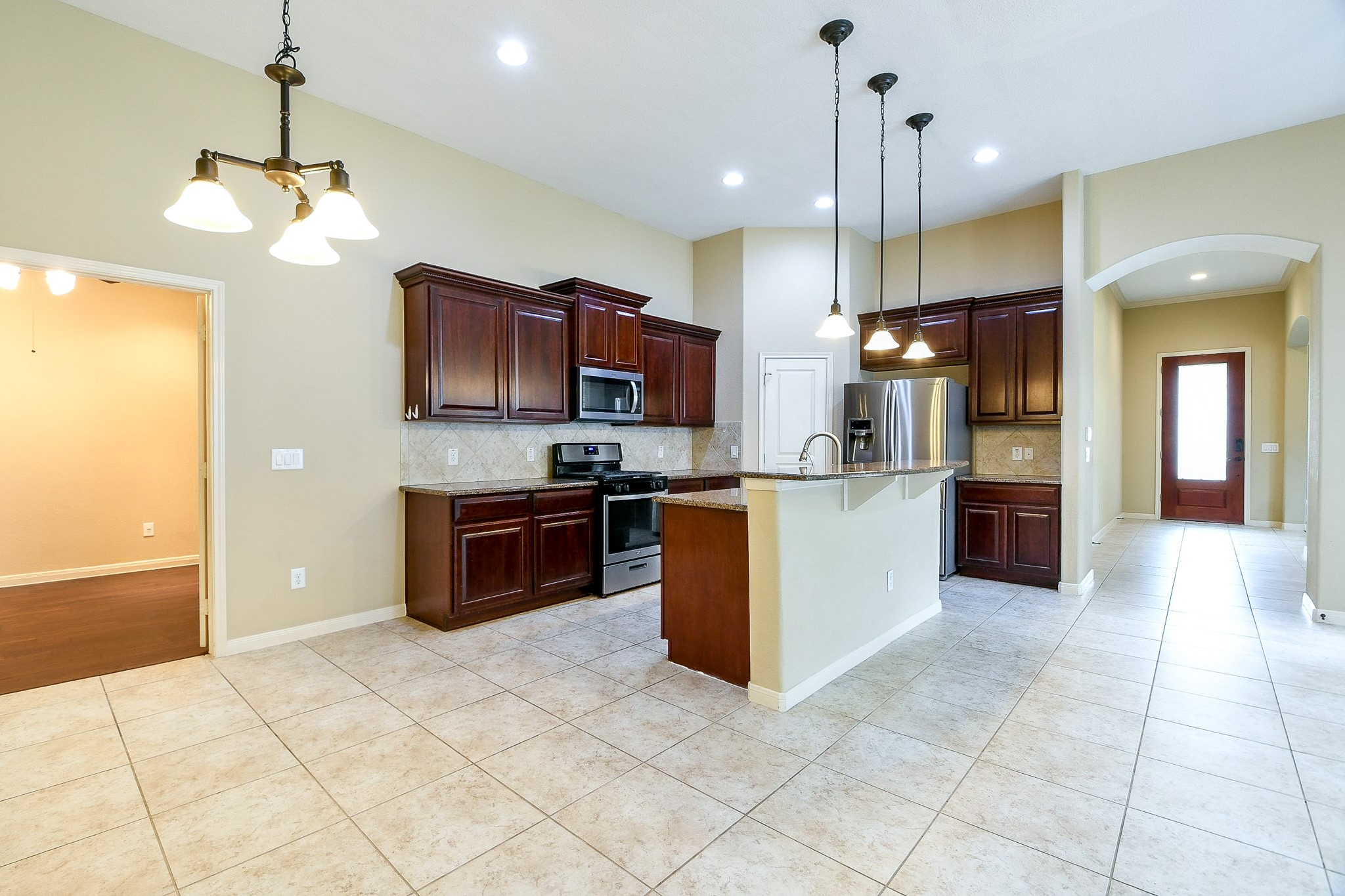 1619 Ralston Branch Way Sugar Land, TX 77479 - Photo 7 of 20 a kitchen with kitchen island granite countertop a stove a sink a counter top space cabinets and a counter top space