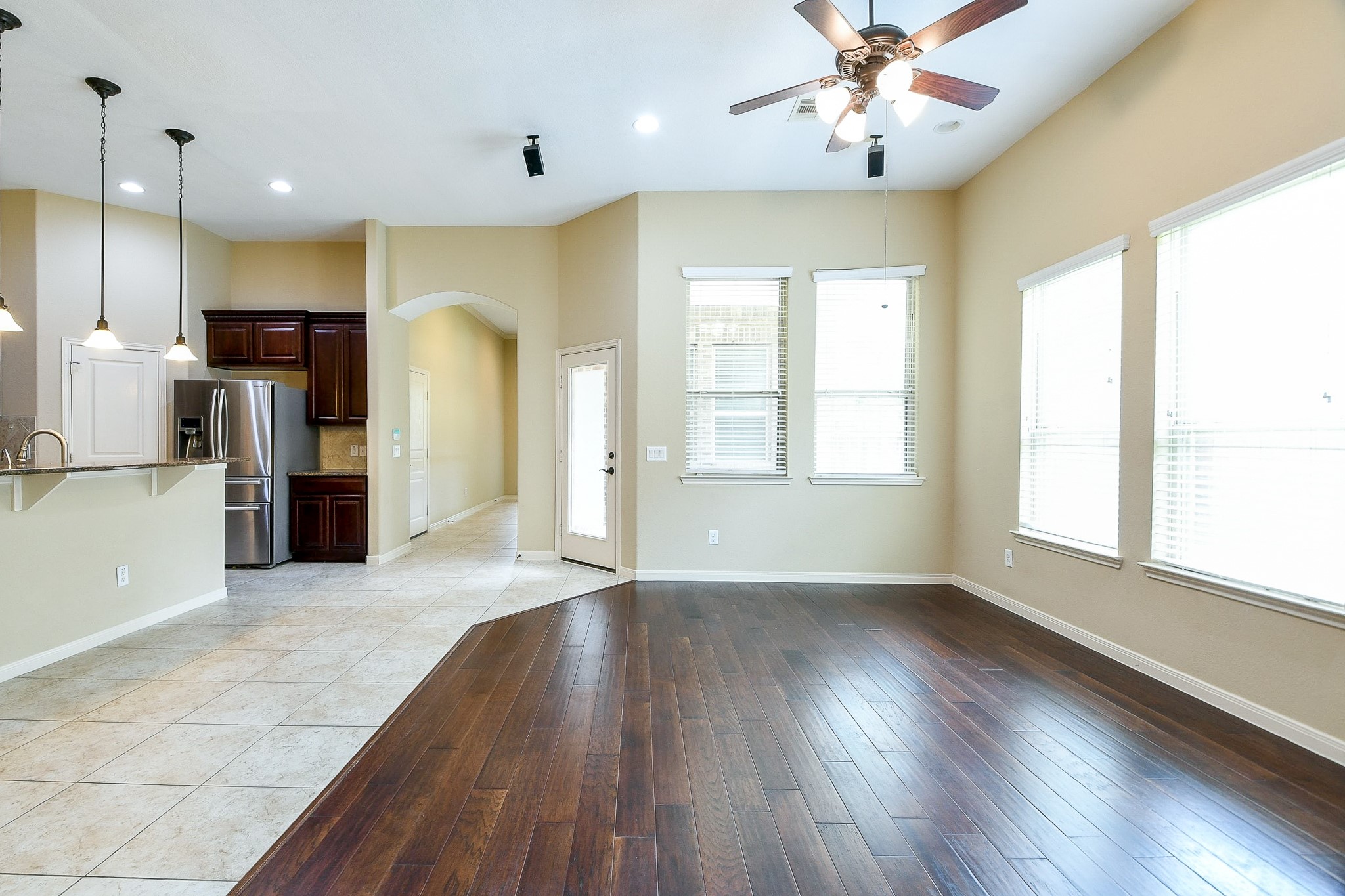 1619 Ralston Branch Way Sugar Land, TX 77479 - Photo 8 of 20 an empty room with wooden floor and a kitchen
