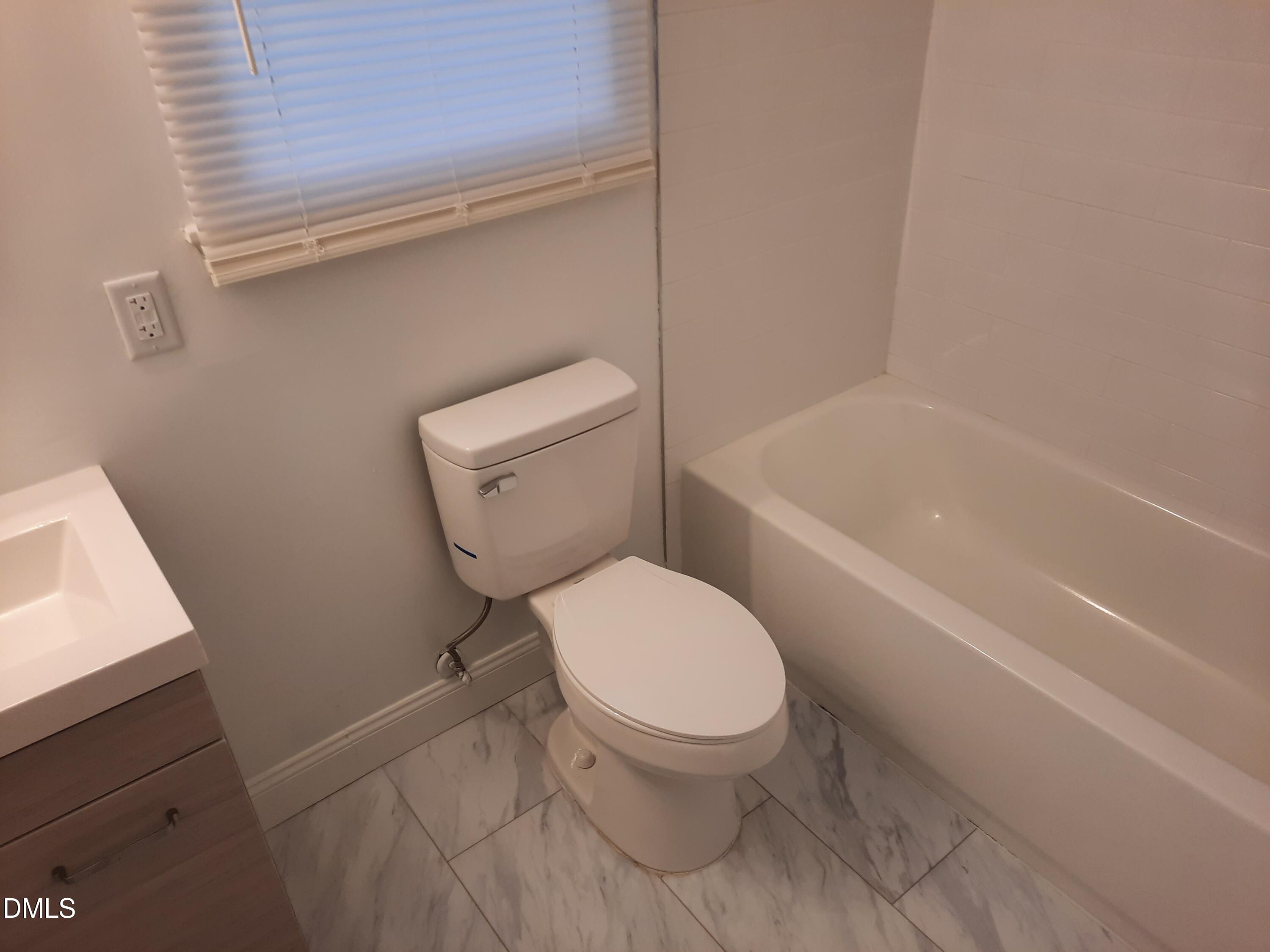 404 Lynn Road Durham, NC 27703 - Photo 2 of 5 a white toilet sitting next to a bath tub