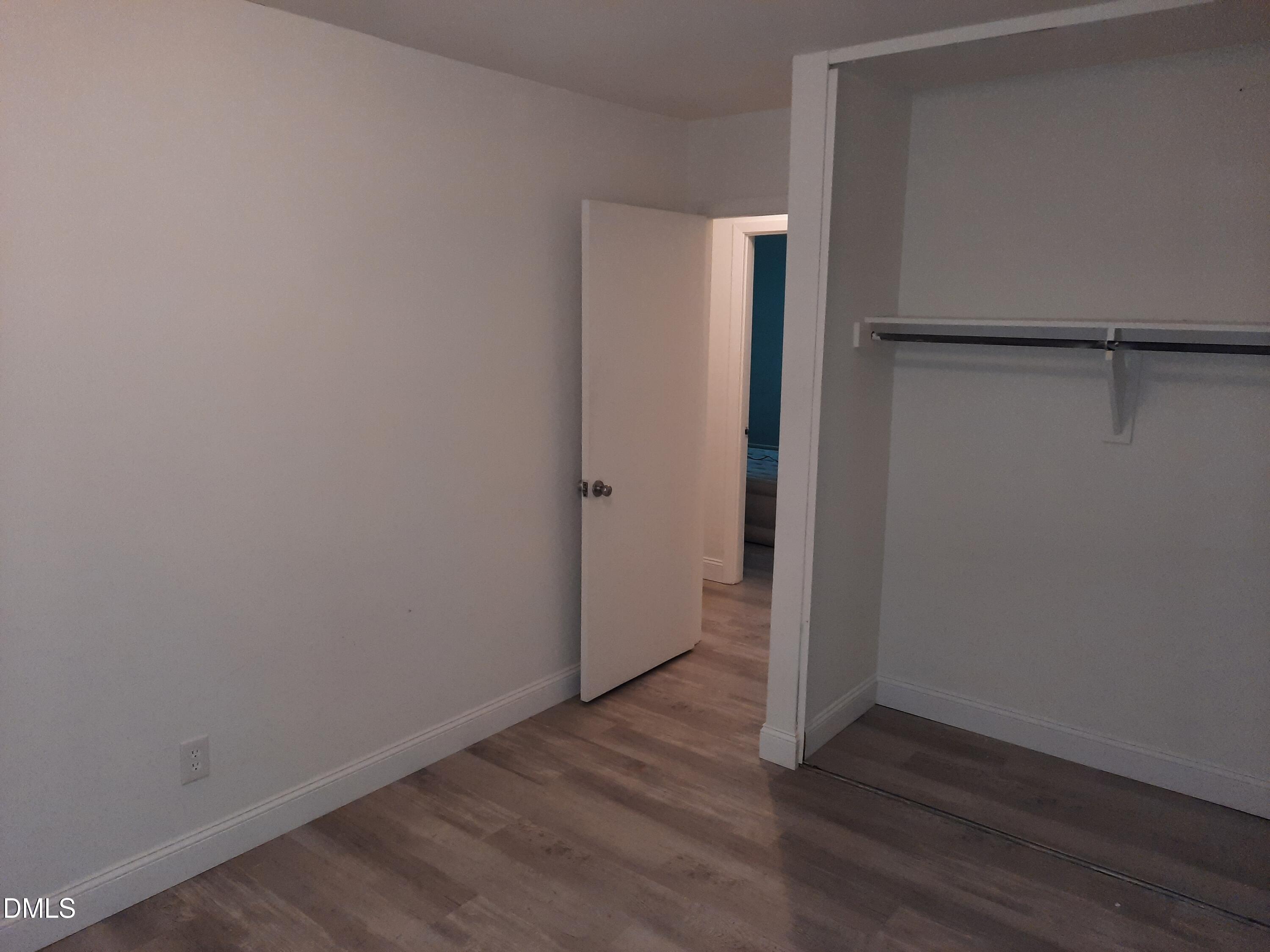 404 Lynn Road Durham, NC 27703 - Photo 4 of 5 a view of an empty room with wooden floor and closet