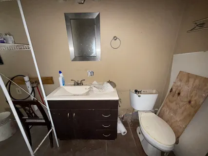 a bathroom with a toilet sink and mirror