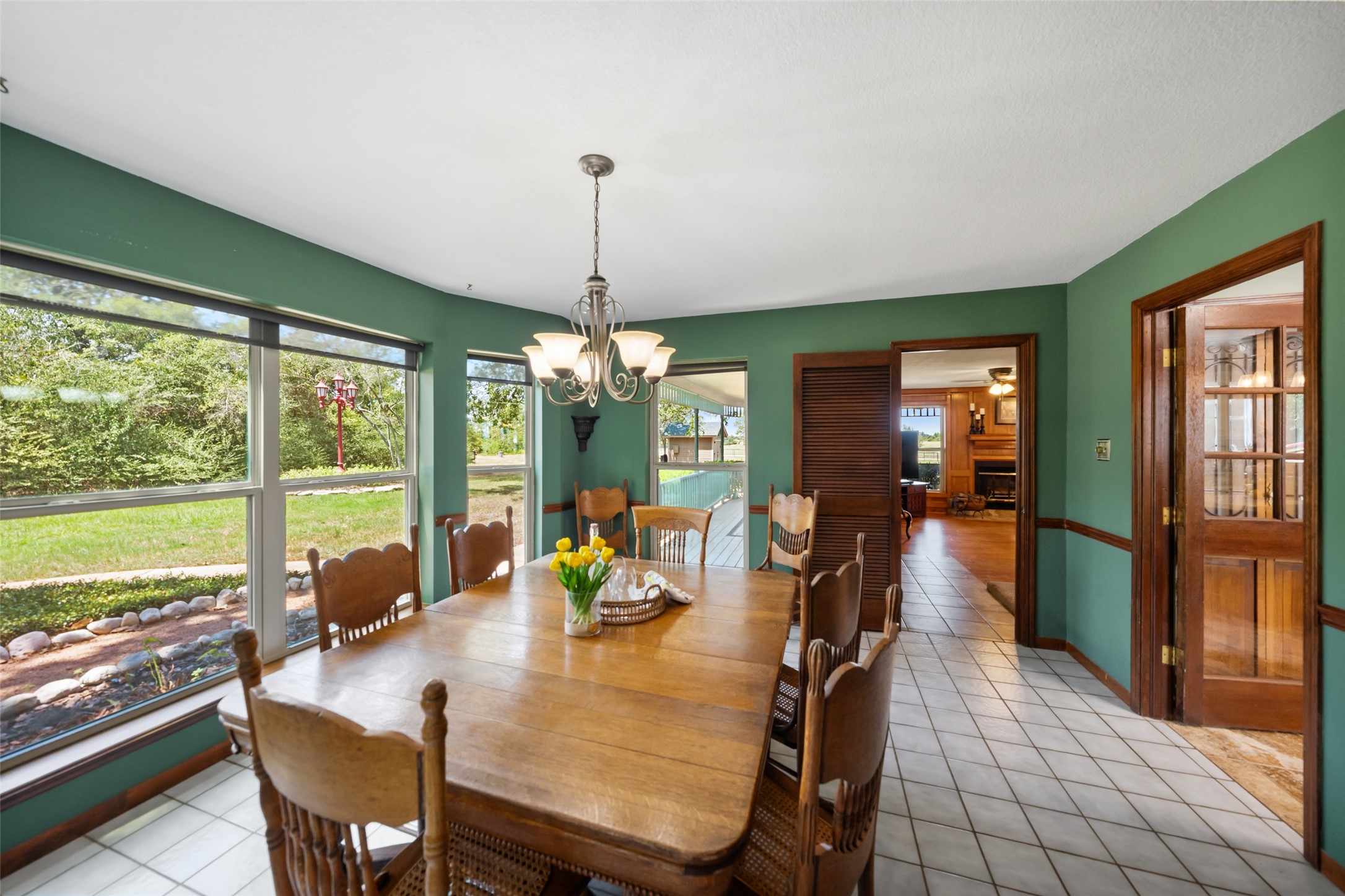 25948 Nelson Road Hempstead, TX 77445 - Photo 13 of 46 Bright breakfast area surrounded by windows, featuring hardwood flooring and views of the mature trees and surrounding grounds.