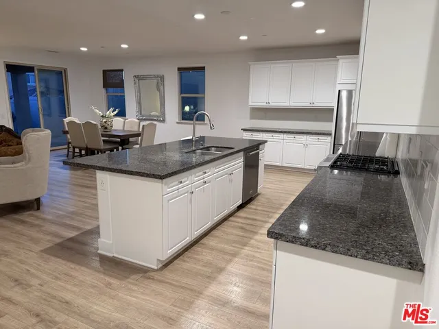 a large kitchen with stainless steel appliances granite countertop a sink and a stove