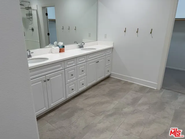a spacious bathroom with a double vanity sink and mirror