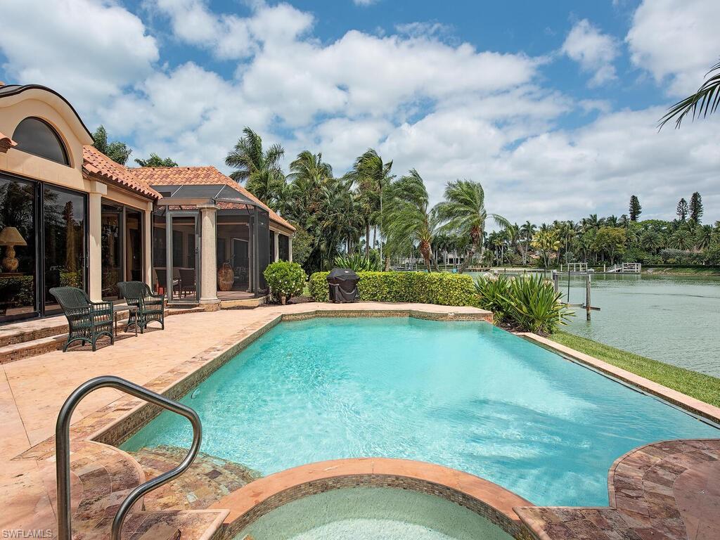 3133 Rum Row Naples, FL 34102 - Photo 11 of 35 a view of a house with swimming pool and a yard
