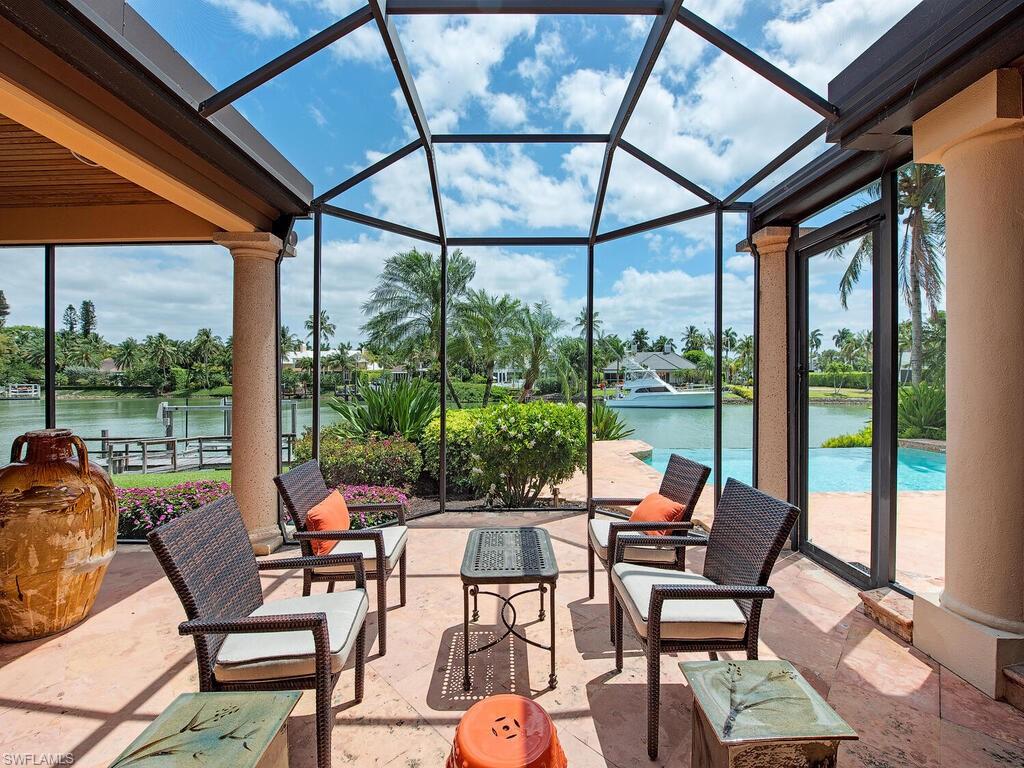 3133 Rum Row Naples, FL 34102 - Photo 12 of 35 a view of a patio with table and chairs and couches with wooden floor