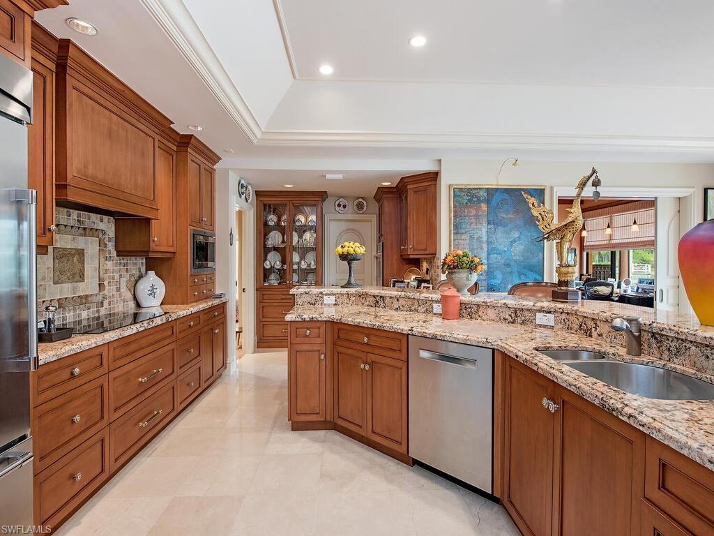 3133 Rum Row Naples, FL 34102 - Photo 19 of 35 a large kitchen with stainless steel appliances granite countertop a sink and cabinets
