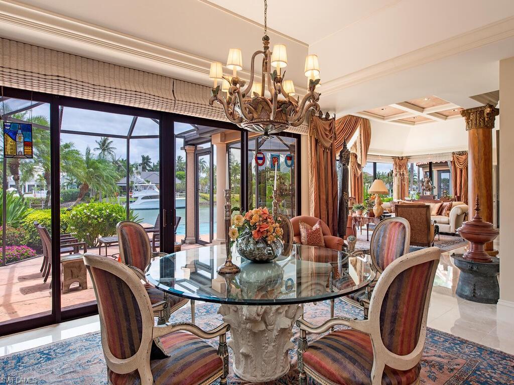 3133 Rum Row Naples, FL 34102 - Photo 20 of 35 a view of a dining room with furniture wooden floor and chandelier