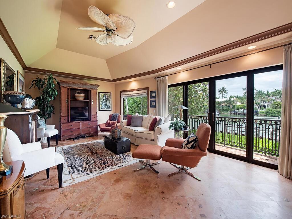 3133 Rum Row Naples, FL 34102 - Photo 22 of 35 a living room with furniture and a floor to ceiling window