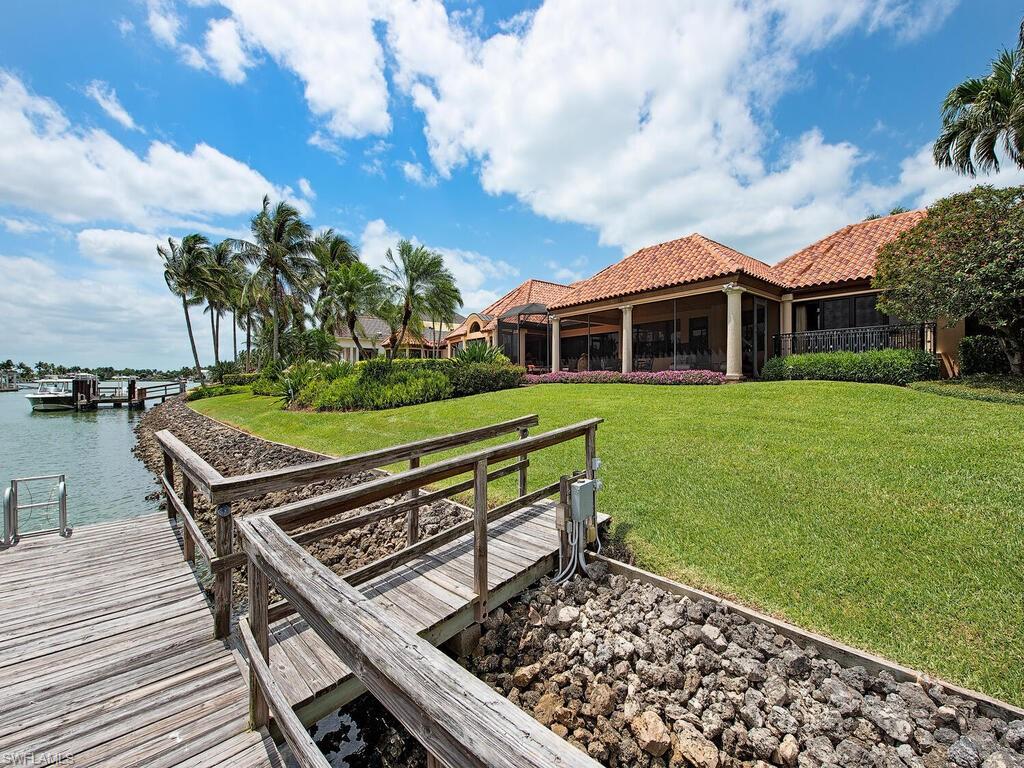 3133 Rum Row Naples, FL 34102 - Photo 9 of 35 a view of a chairs and table on the wooden deck