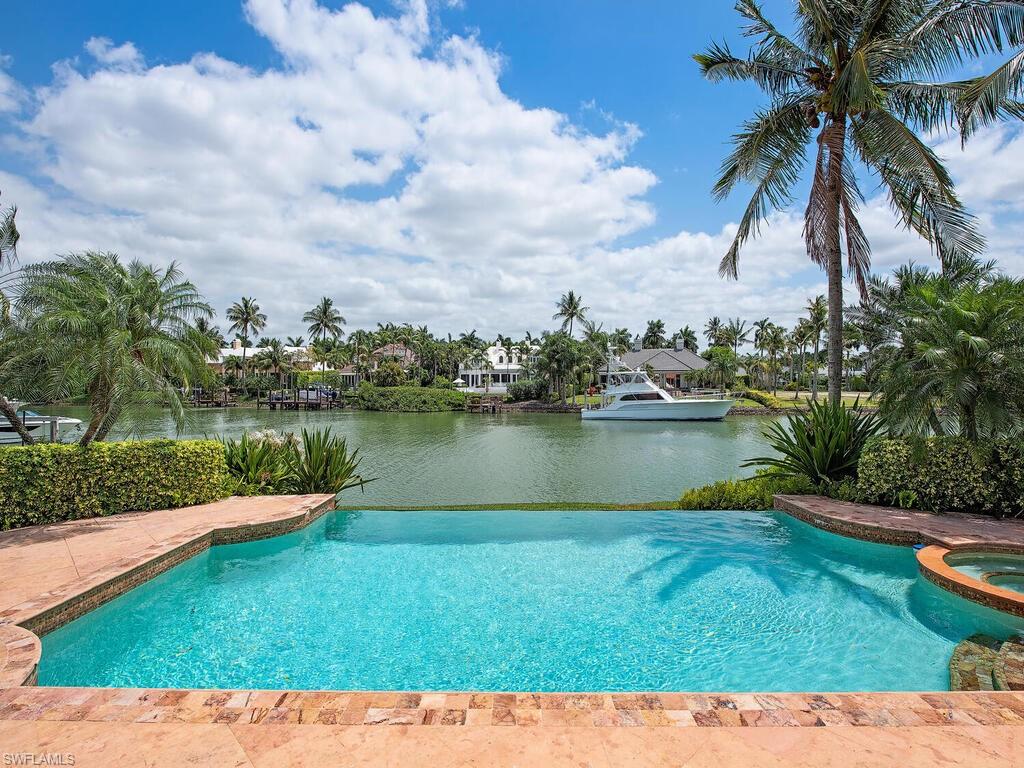 3133 Rum Row Naples, FL 34102 - Photo 10 of 35 a view of a lake with a yard and potted plants