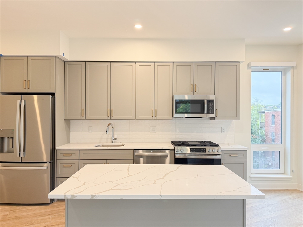 500 Talbot Avenue, Unit 403 Boston, MA 02124 - Photo 2 of 25 a kitchen with stainless steel appliances a refrigerator stove microwave and cabinets