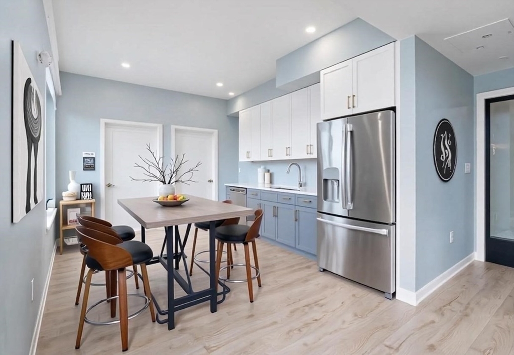 500 Talbot Avenue, Unit 403 Boston, MA 02124 - Photo 22 of 25 a kitchen with stainless steel appliances a refrigerator a stove a dining table and chairs