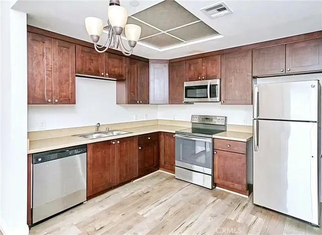 a kitchen with granite countertop stainless steel appliances and wooden cabinets