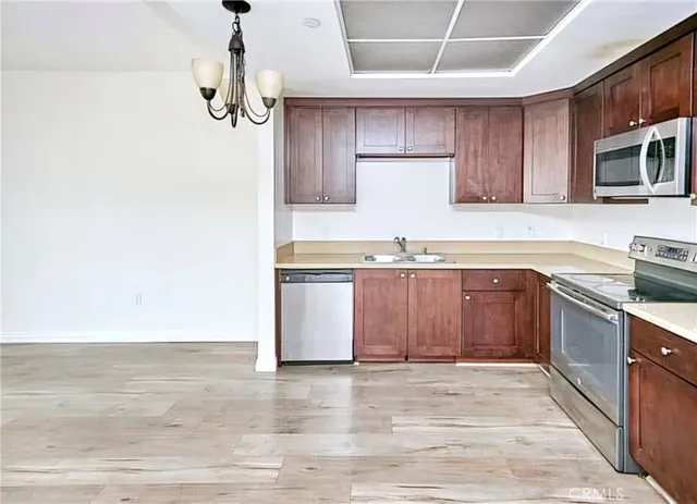 a kitchen with stainless steel appliances granite countertop a sink a stove a microwave and wooden floors