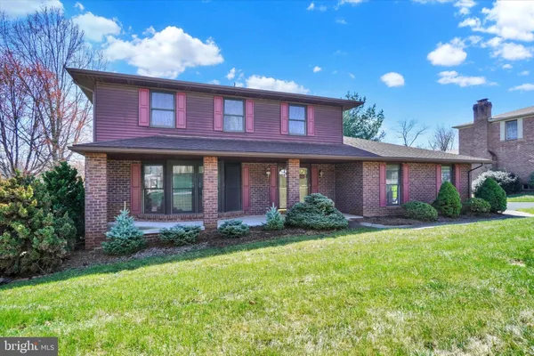a view of a brick house with a yard
