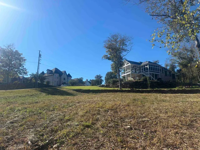 a front view of a house with a yard and mountain view